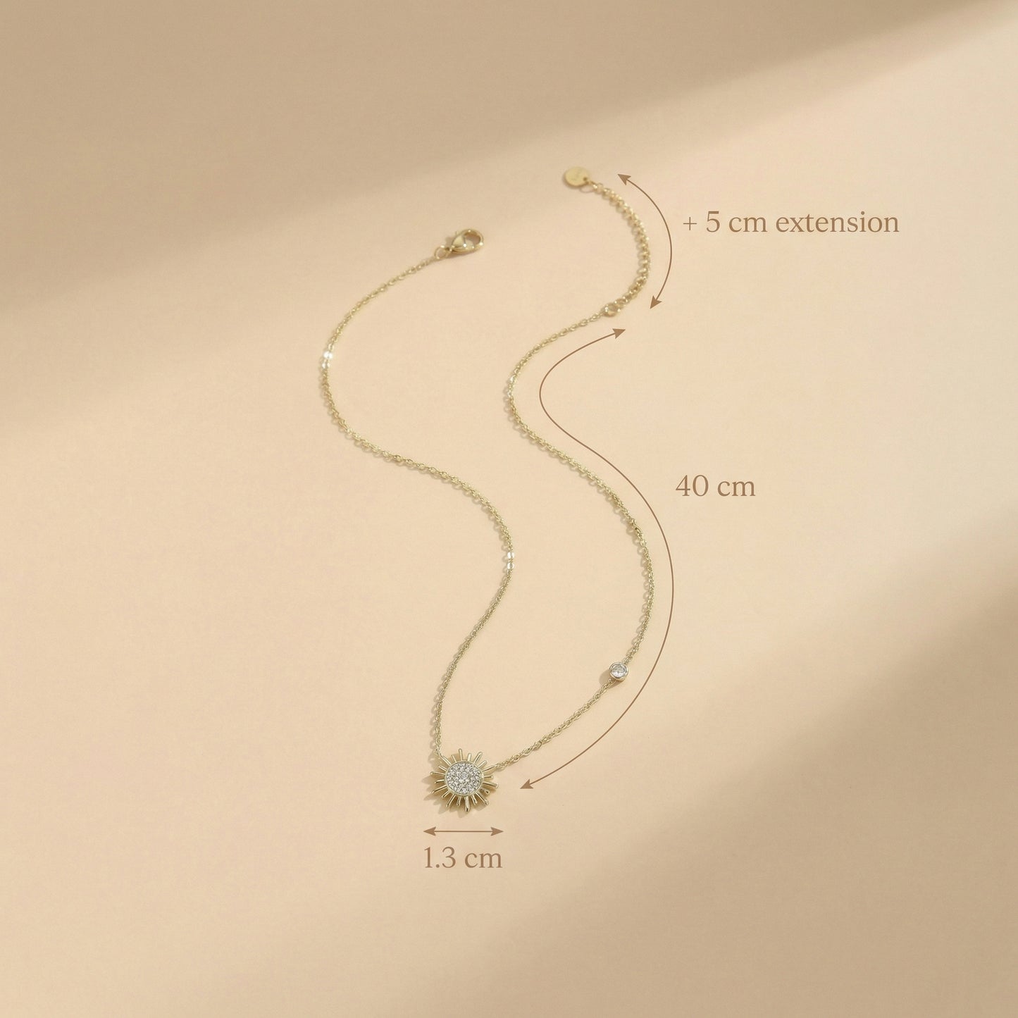 Gold bracelet with measurements on a beige background