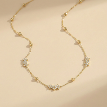 Gold necklace with diamond accents on a beige background