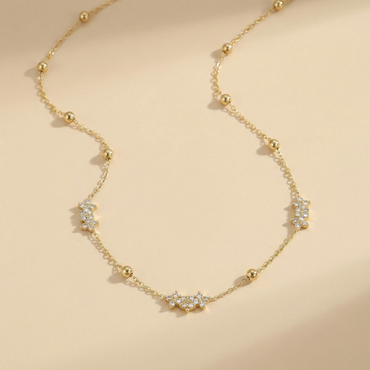 Gold necklace with diamond accents on a beige background