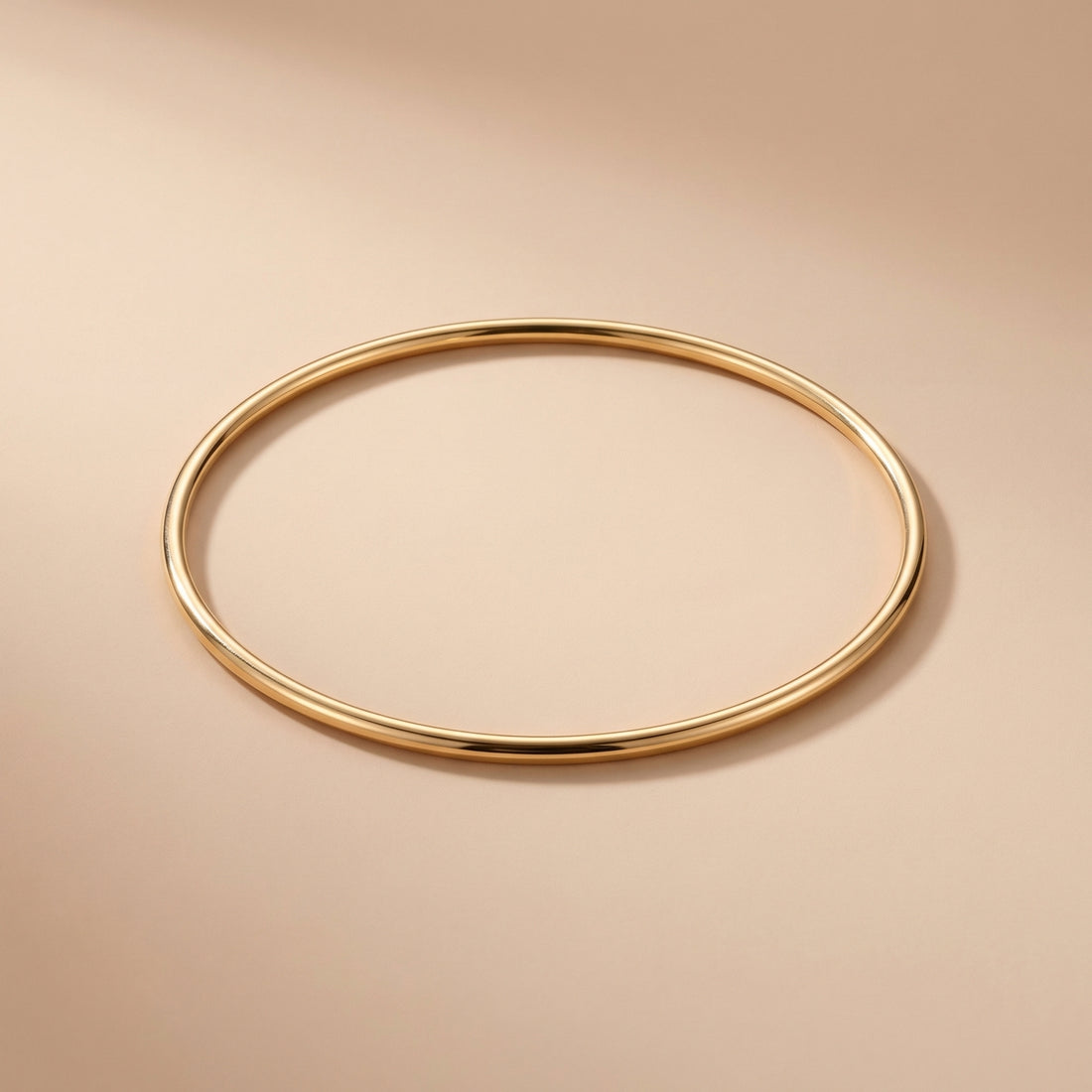 Gold bangle on a beige background