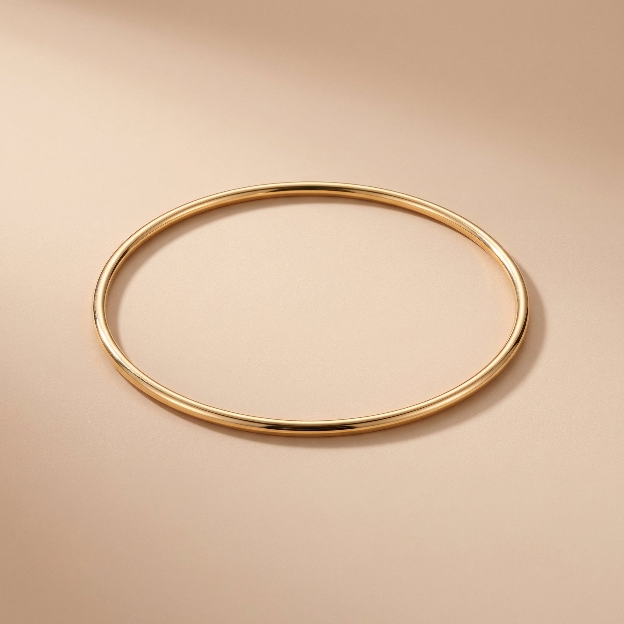 Gold bangle on a beige background
