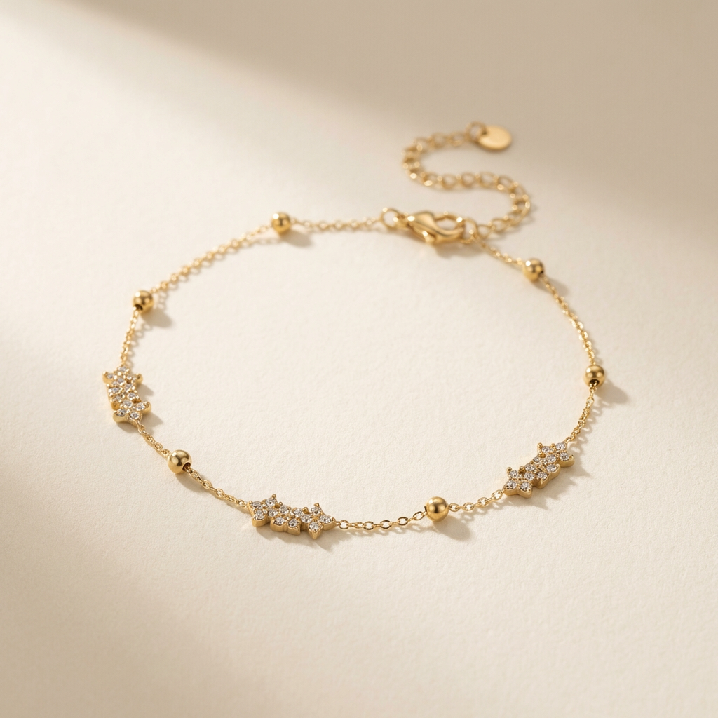 Gold bracelet with star-shaped charms on a beige background