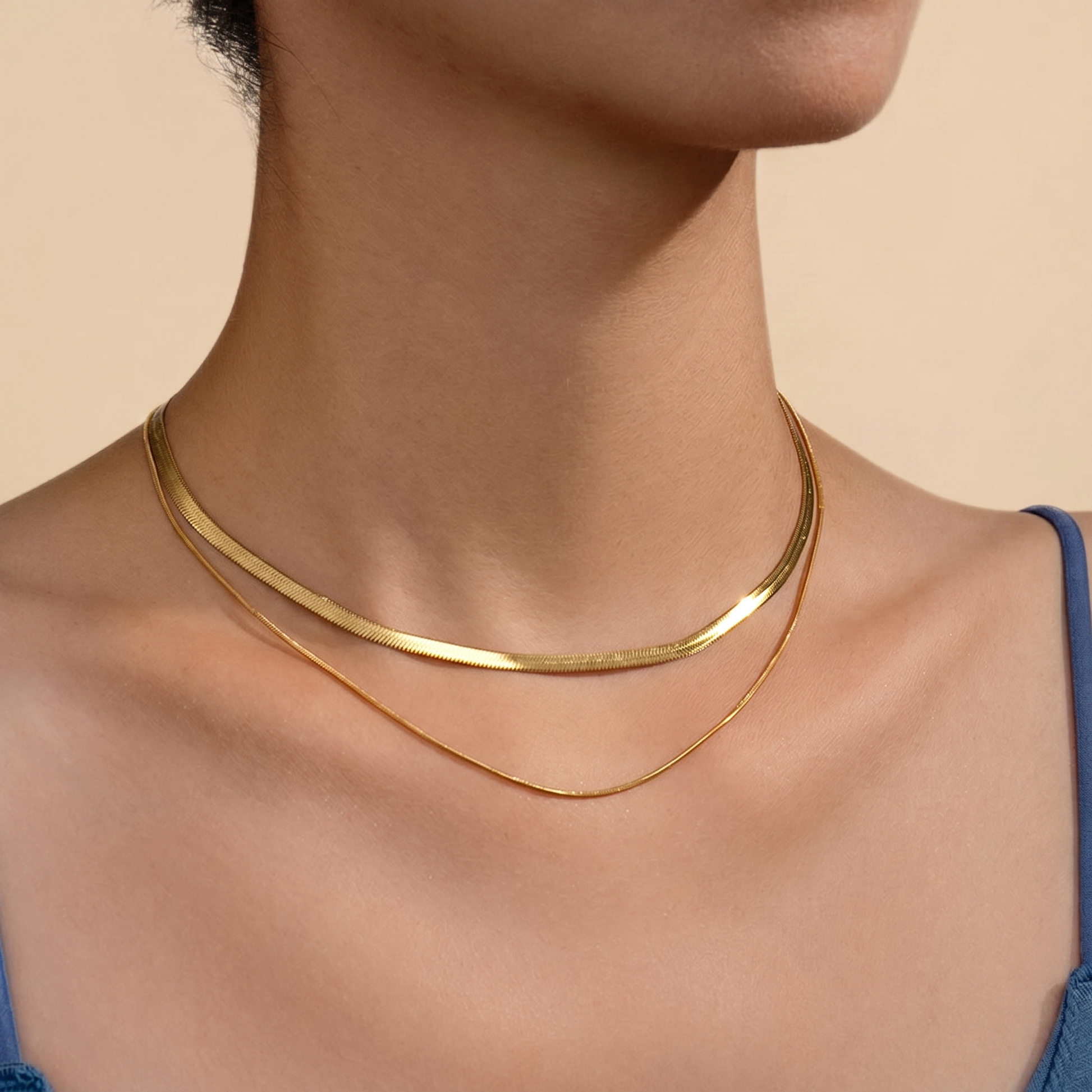Flat snake chain choker necklace on a soft beige background