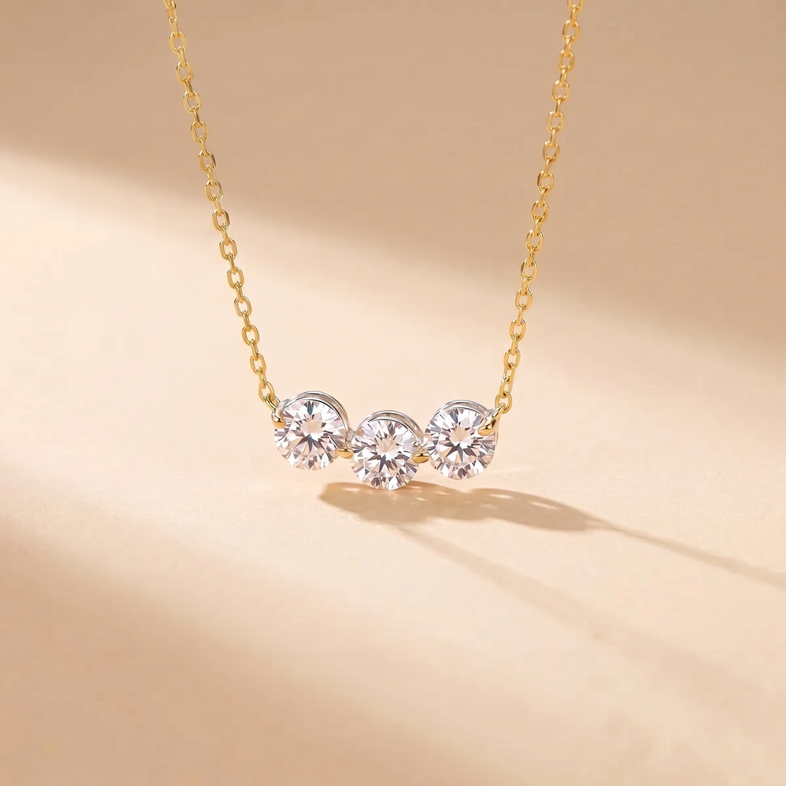 Sterling silver three-stone zircon necklace on a soft beige background