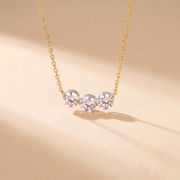 Sterling silver three-stone zircon necklace on a soft beige background