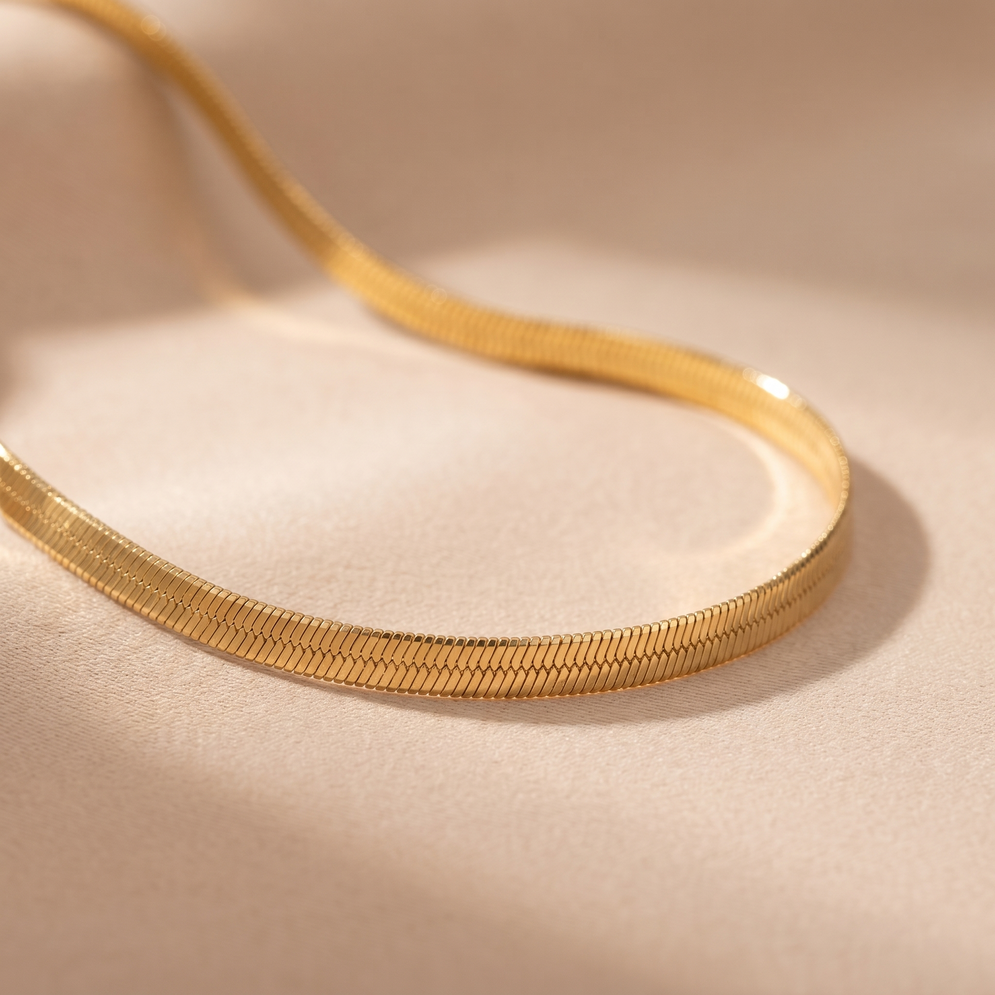 Macro detail of the flat snake chain choker on beige