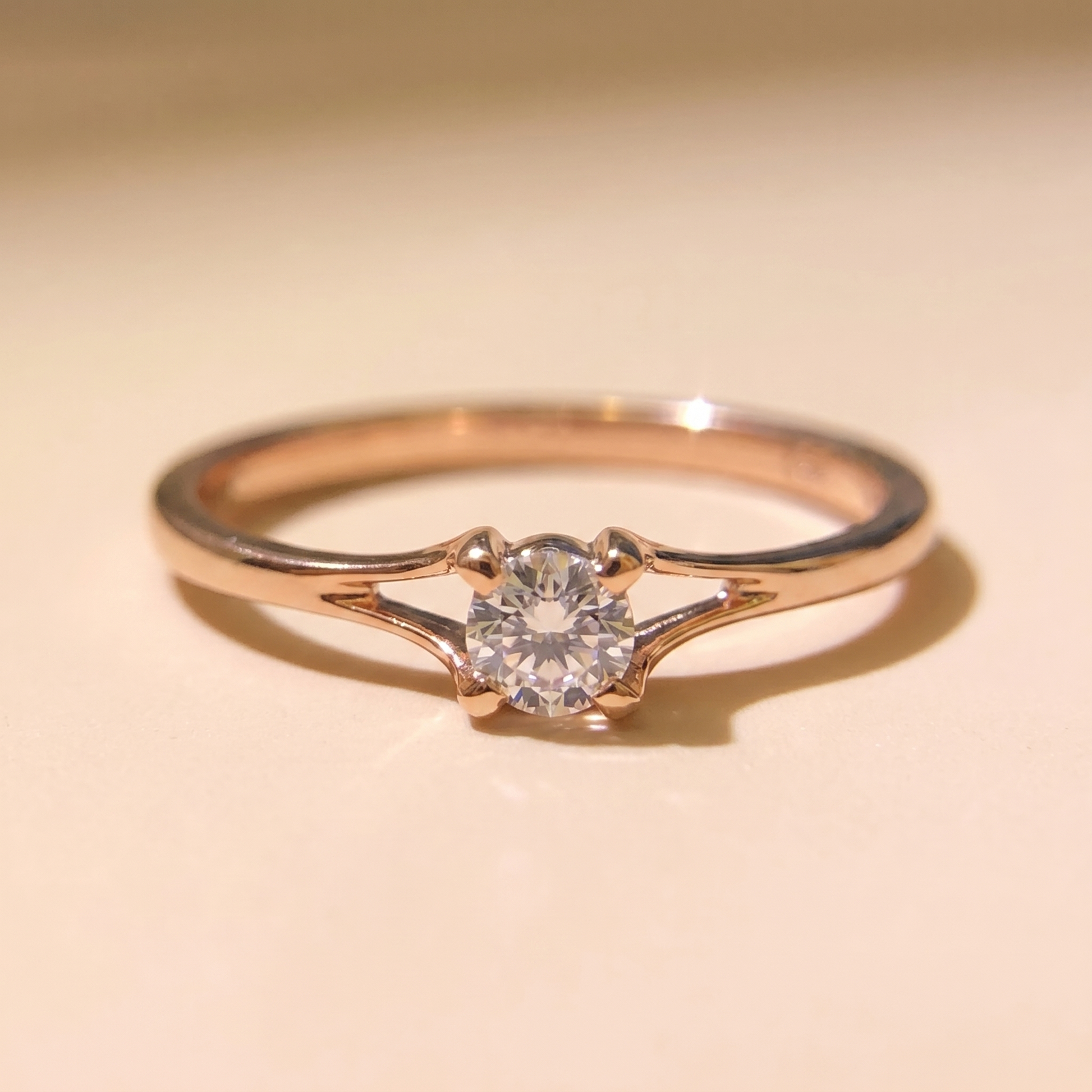 Macro detail of the 4mm cubic zirconia solitaire ring on beige