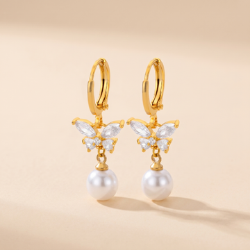 Butterfly Pearl Drop Earrings on soft beige background