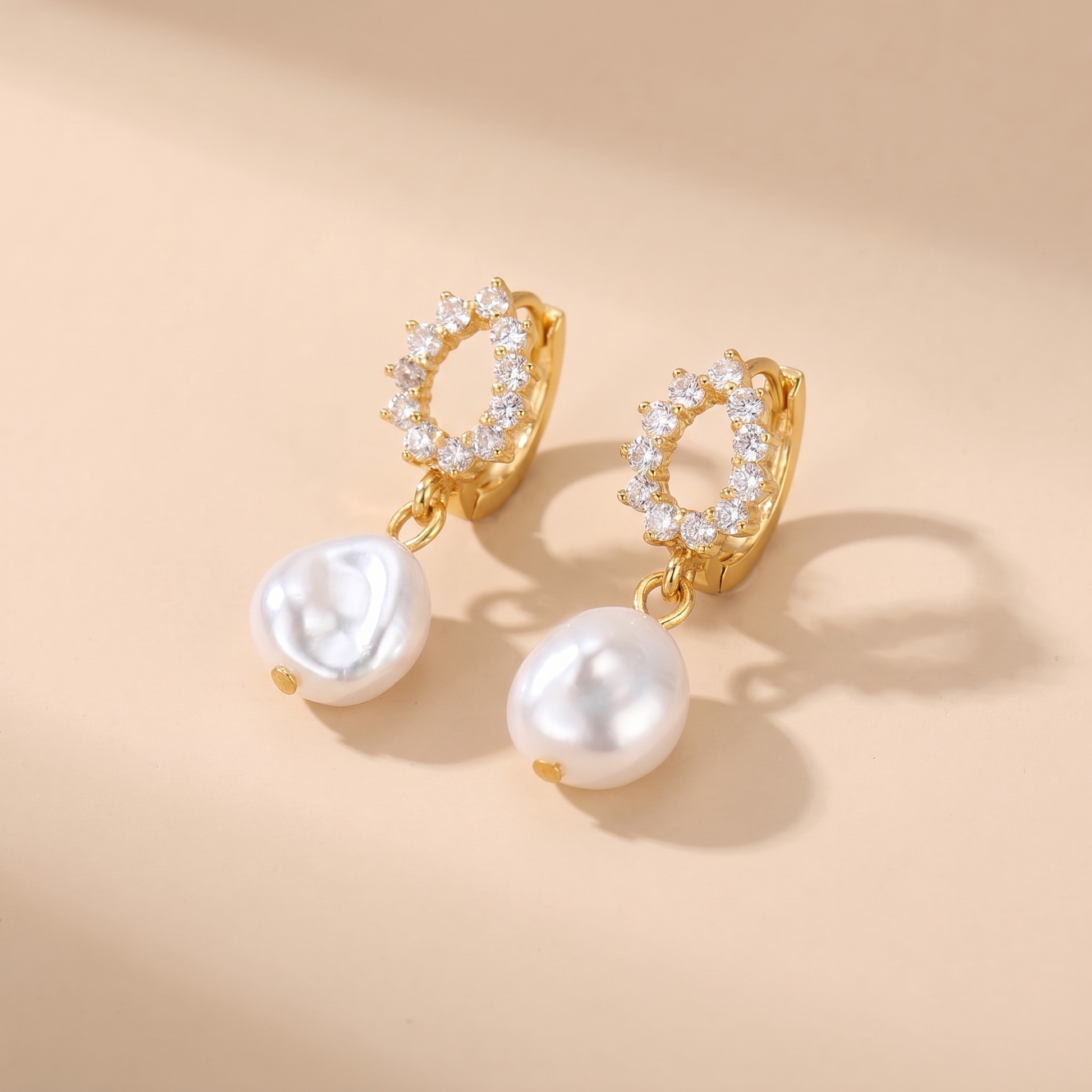 Pave Pearl Drop Huggie Earrings on soft beige background