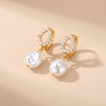Pave Pearl Drop Huggie Earrings on soft beige background