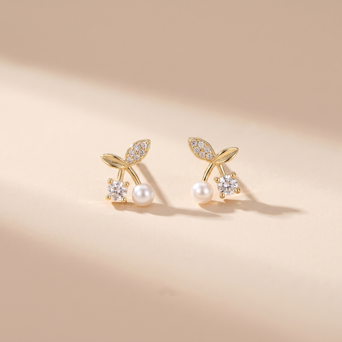 Petite Pearl Sprig Stud Earrings on soft beige background