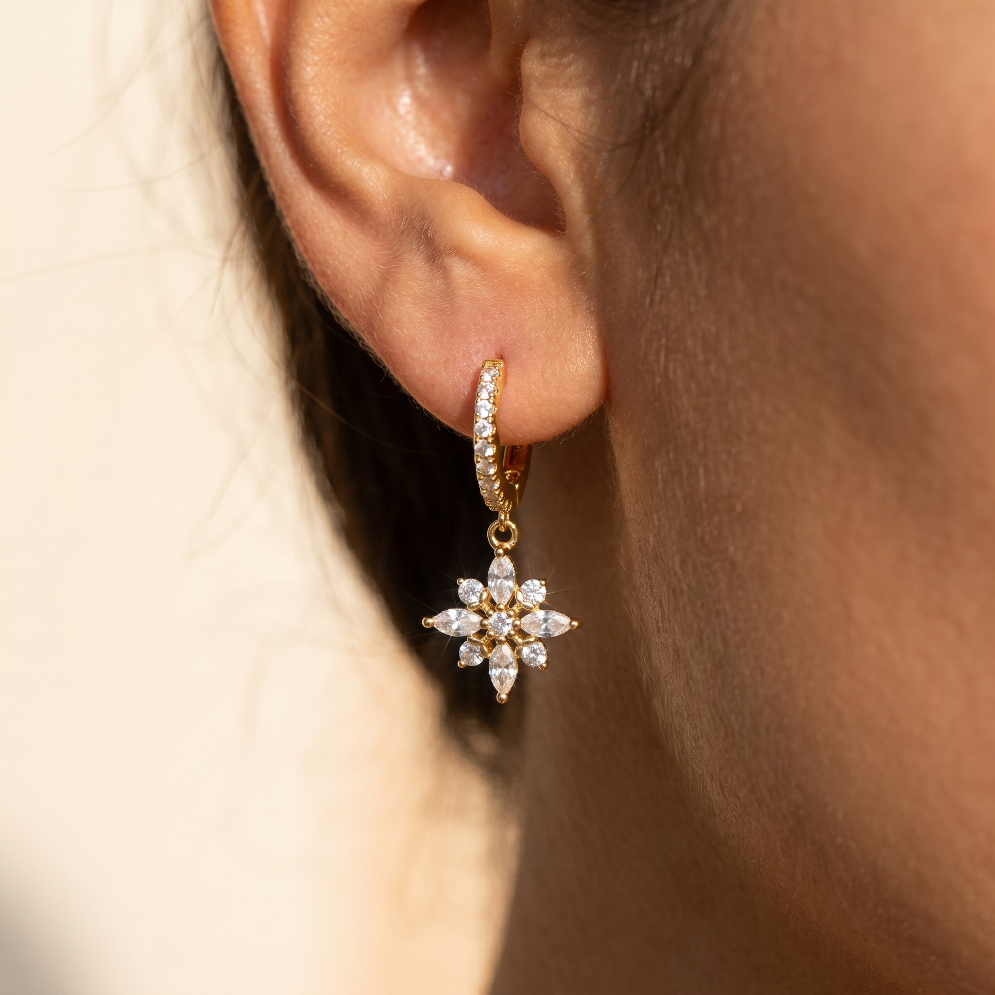 Crystal Flower Huggie Drop Earrings close-up on ear