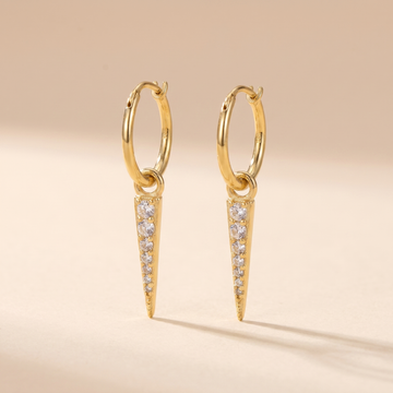 Pave Spike Dagger Huggie Earrings on soft beige background