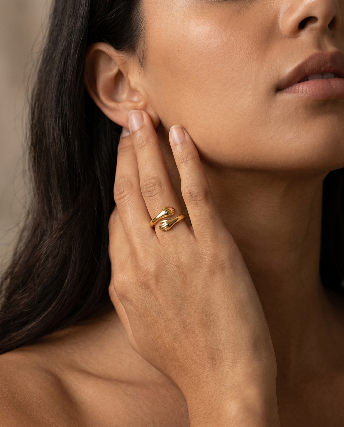 Gold hug ring worn, hand resting near the ear